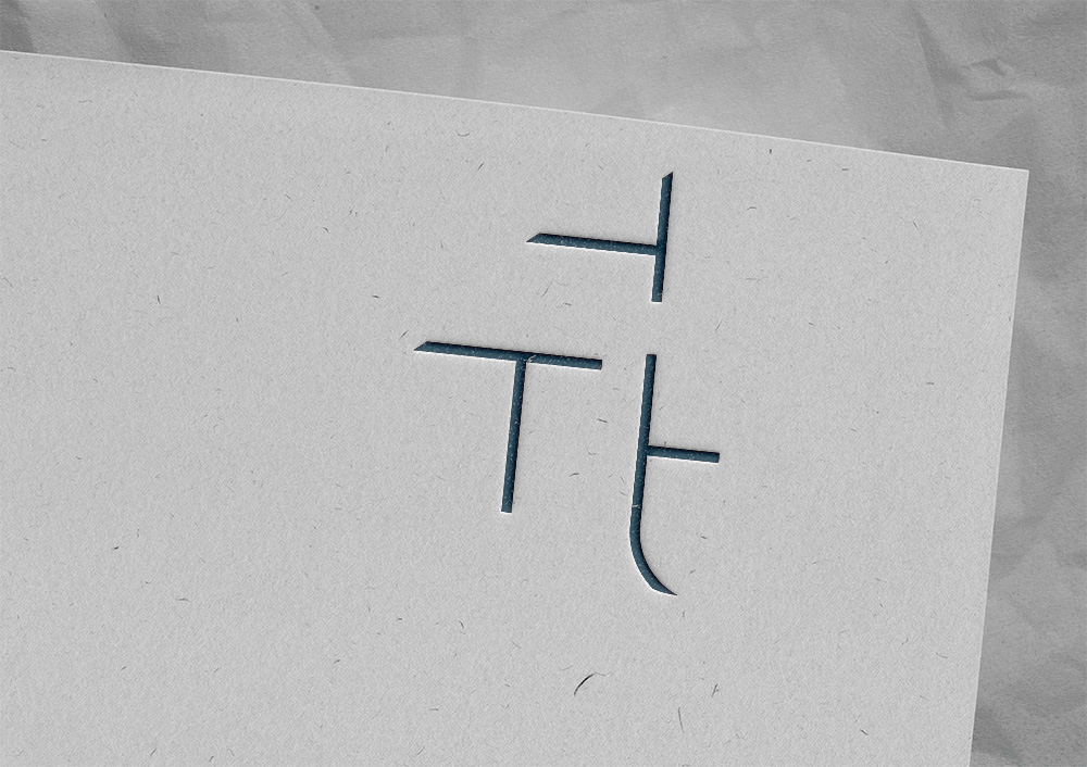 A piece of paper with the negative space TTT logo in deep blue.
